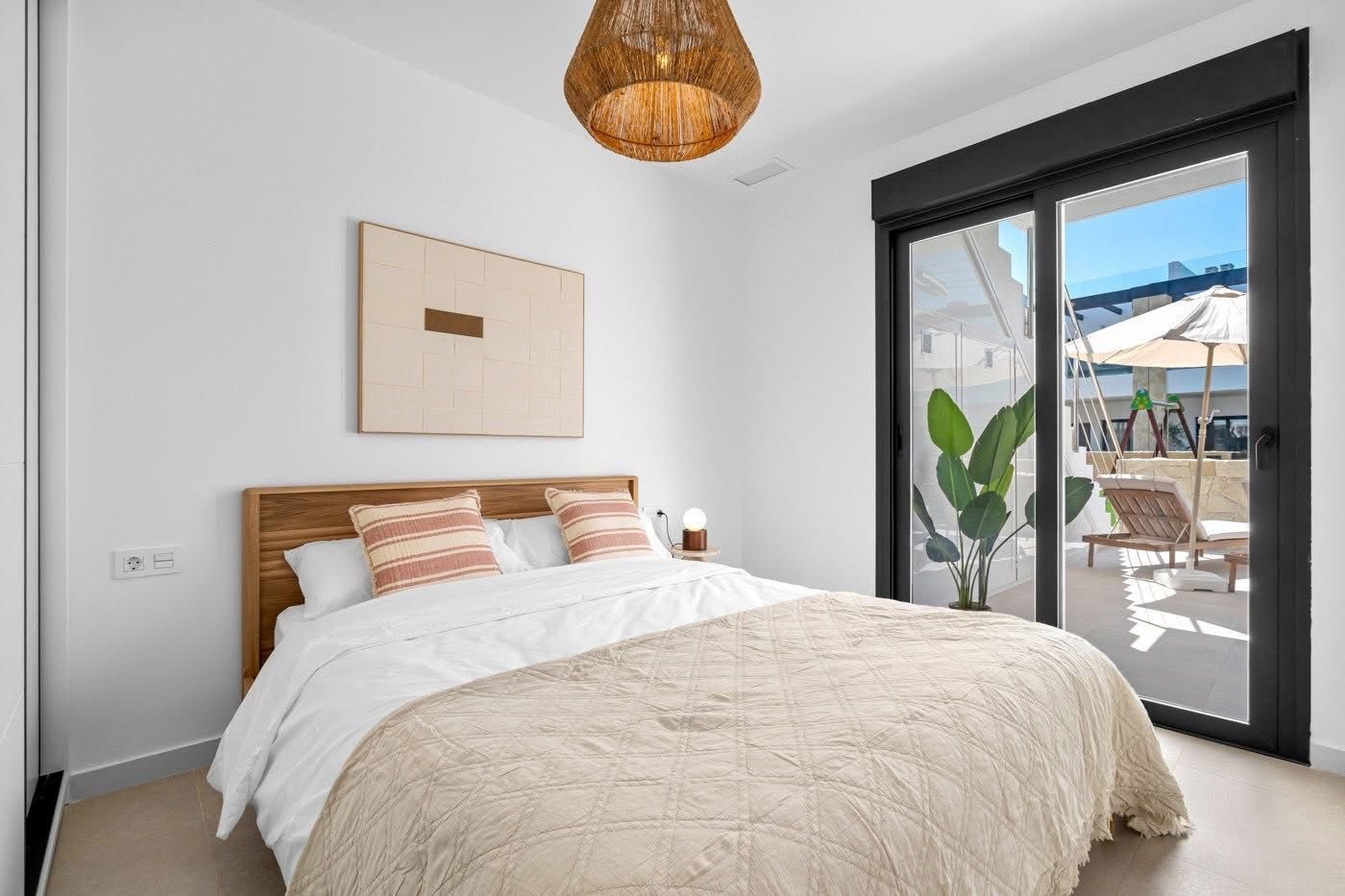 Helles Schlafzimmer mit Doppelbett und Terrassenzugang